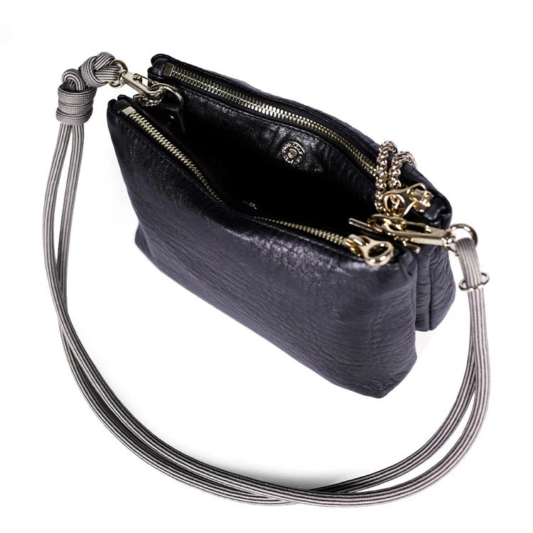 The CRAIE STUDIO - DUO BUBBLE NOIR HANDBAG by CRAIE STUDIO is showcased from above on a white background. This luxurious black bubble leather handbag features elegant gold zippers, two spacious compartments, and a gray corded strap. Crafted for both style and practicality, this chic double-zipped pouch perfectly balances fashion and function.