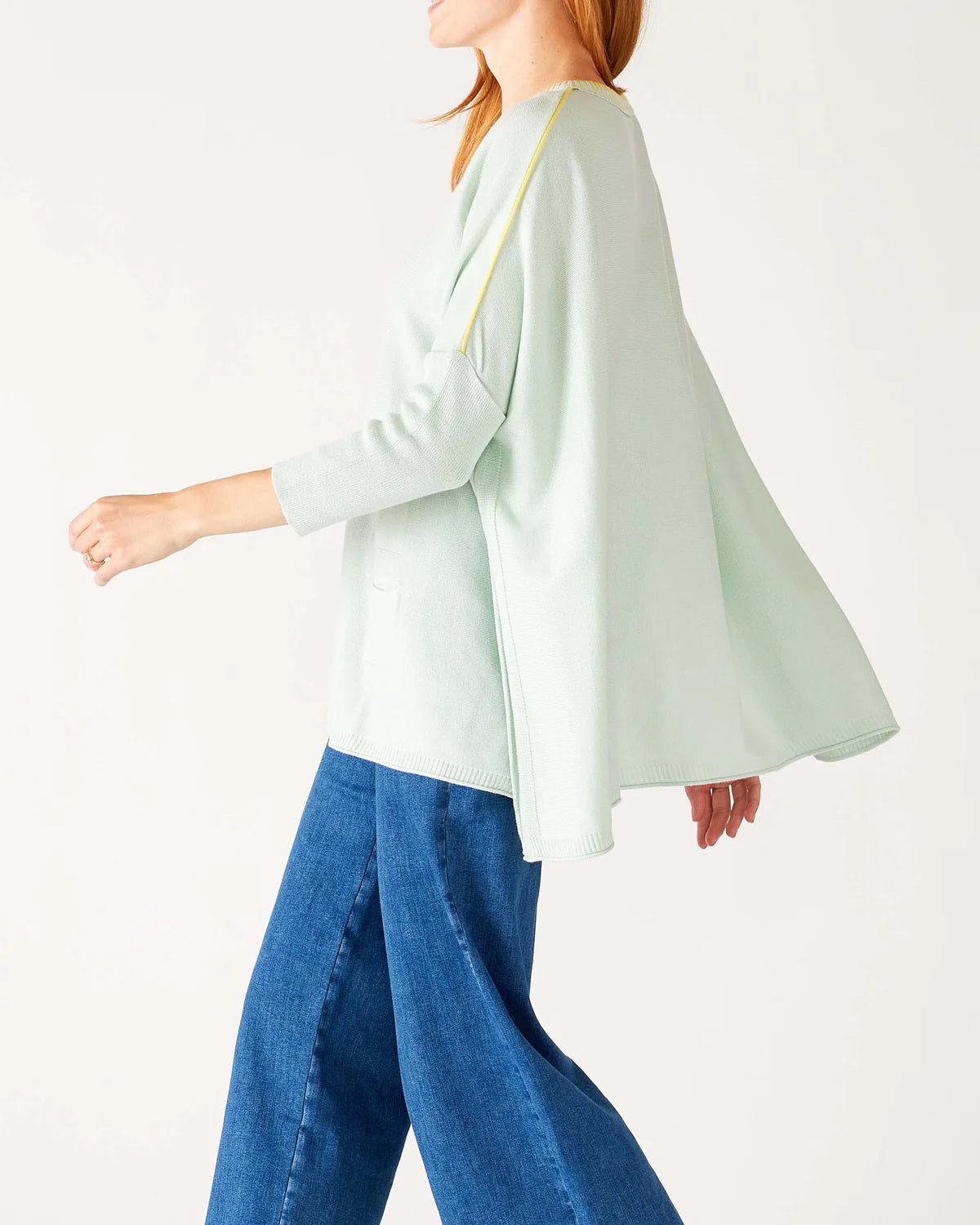 Woman wearing the MERSEA - CATALINA CREWNECK SWEATER, white with two black stripes, paired with denim shorts and a gold necklace—an essential piece from MERSEA for effortless, versatile style.