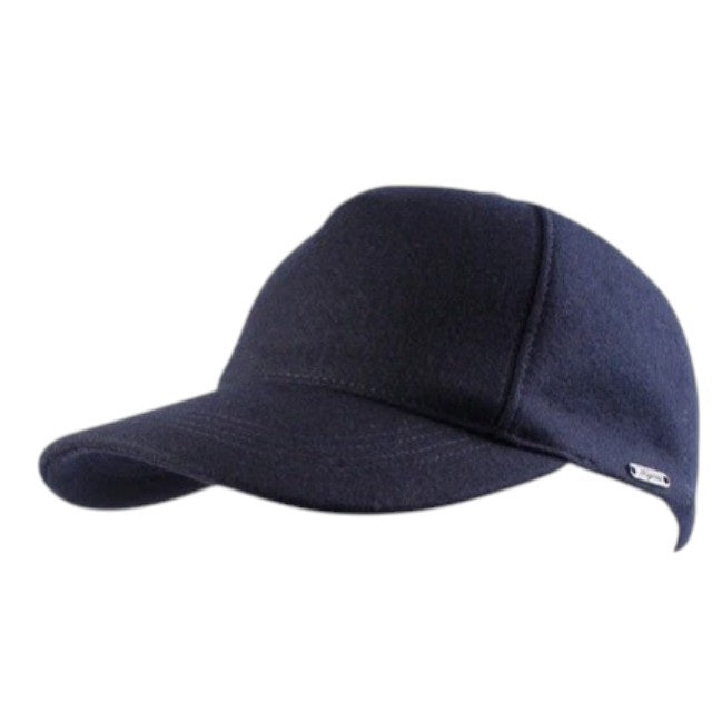 Introducing the WIGENS - CONTEMPORARY WOOL BASEBALL CAP IN DARK BLUE by WIGENS: a premium melton wool cap in a sleek dark blue shade, featuring a curved brim and an elegant small silver tag on the side. Photographed against a white background, this high-quality cap combines stylish design and lasting durability, perfect for everyday wear.