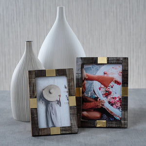 The ZODAX LAGOS HARN AND BRASS PHOTO FRAME 5x7 features textured dark brown and gold accents with a "ZODAX, Five Inches x Seven Inches" insert, adding elegance to your decor.