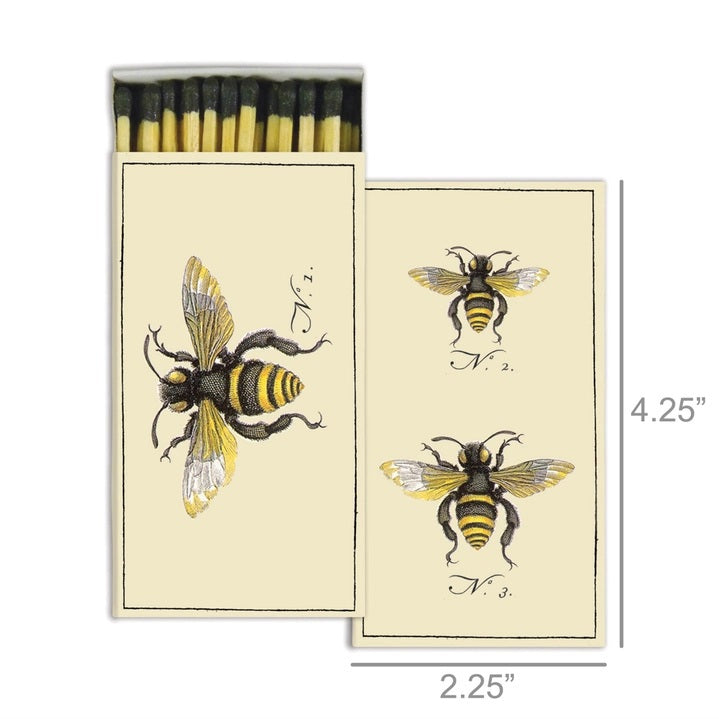The HOMART MATCHES - BEES box contains yellow-tipped safety matches and features a vintage bee illustration on the box, with three labeled bees on an enclosed card—making it a delightful and charming hostess gift.