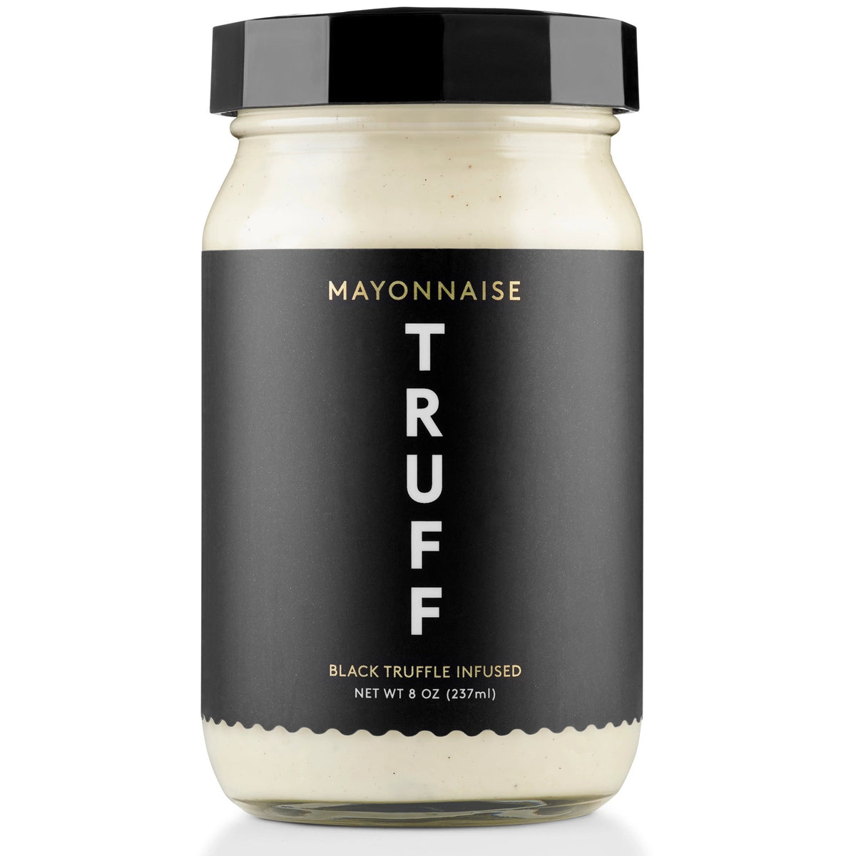 A clear jar of TRUFF - MAYONNAISE by TRUFF HOT SAUCE features a black label with gold text and a black lid. The label says "Mayonnaise TRUFF Black Truffle Infused Net Wt 8 oz (237 ml)." Elevate your dishes with this gourmet mayo.