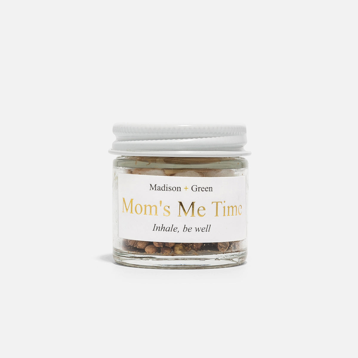 The MADISON GREEN Mom's Me Time Stress Relief Aromatherapy Inhaler is a small glass jar with a white lid, filled with dried herbs and organic essential oils to help soothe stress.