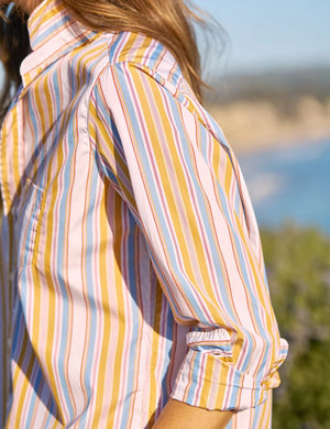 The FRANK & EILEEN EILEEN Relaxed Button Up in Italian cotton stripe features vertical yellow, blue, white, and orange stripes with long sleeves, a left chest pocket, open collar, and rolled-up sleeves for a flattering look.