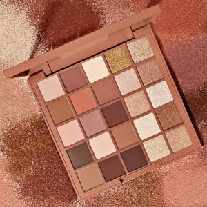 The JASON WU BEAUTY - FLORA 25 EYESHADOW artistry shadow palette contains 25 shades arranged in a 5x5 grid, ranging from light beiges and pinks to darker browns and rich shimmers. It features both shimmer and matte shades to inspire endless creativity.