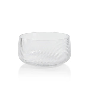 The CONNAUGHT RIPPLED GLASS BOWL - MEDIUM by ZODAX is a transparent, round glass bowl featuring a smooth rim and an elegant, diagonal ribbed texture on its surface. Measuring 21.59 cm x 10.8 cm (8.5 in x 4.25 in), this bowl is showcased against a plain white background, emphasizing its refined simplicity.
