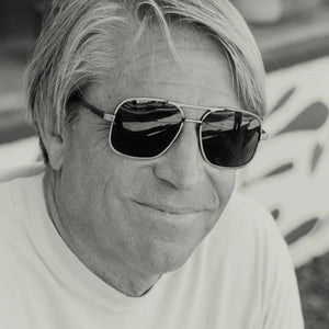 Front view of CADDIS - METAMODERNIST SCOUT SUNGLASSES by CADDIS, featuring an aviator-style sleek metal alloy frame and dark green premium tinted lenses, displayed on a white background.