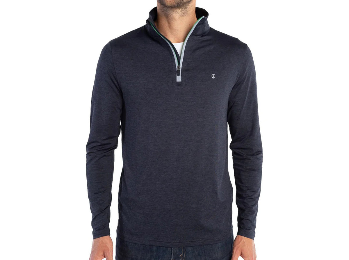 A man wears the CRIQUET Feather Performance Quarter Zip Pullover in Heather Black with a high collar and small chest logo, paired with blue jeans. His face is not visible; his arms are relaxed at his sides.