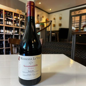 A bottle of MASSERIA LI VELI SUSUMANIELLO 2023 by WINEBOW, crafted from distinguished Puglian grape varieties, with a red foil top and a cream-colored label featuring black and red text, set against a plain white background.