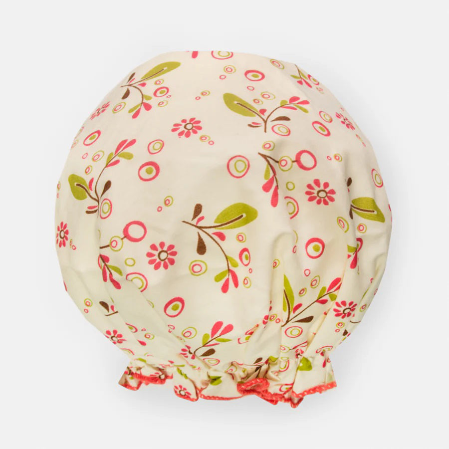 The BATH ACCESSORIES COMPANY&#39;s BOUFFANT SHOWER CAP - OLIVE LEAVES features a delightful floral pattern in pink, green, and brown on a light beige background. Its elastic edge ensures a snug fit, and the waterproof inner layer keeps your hair dry and protected.