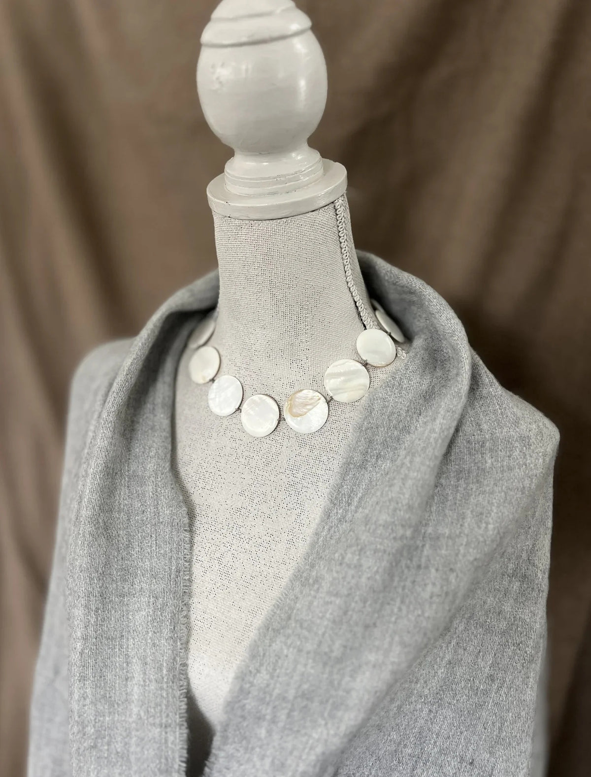 The ANN LIGHTFOOT Mother of Pearl Disc Ras Du Cou Necklace features an elegant arrangement of round, flat, iridescent mother-of-pearl discs, each connected by small links and finished with a sterling silver clasp, beautifully displayed in a circle on a white background.