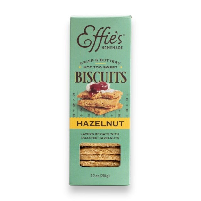 EFFIES - HAZELNUT BISCUIT by EFFIES HOMEMADE comes in a box featuring an image of stacked biscuits topped with jam. The packaging describes them as “crisp & buttery, not too sweet,” and highlights their “layers of oats with roasted hazelnuts.” Enjoy these wholesome biscuits on their own for a satisfying crunch of oats and roasted hazelnuts in every bite, or pair them perfectly with a touch of bittersweet chocolate.