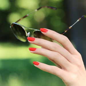 Twelve lipstick swatches in different shades of red, each labeled with its name and undertone, are arranged in a grid with descriptive text over each swatch—perfectly coordinated to complement your favorite MANUCURIST - GREEN™ NAIL POLISH IN RED CORAL by MANUCURIST INC for a bold, unified look.