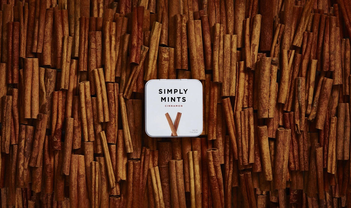 A metal tin labeled "Simply Gum - Cinnamon Mints" by Simply Gum features two cinnamon sticks illustrated below the text, hinting at a delightful fall flavor. These cinnamon mints have a net weight of 1.1 oz (30 g).