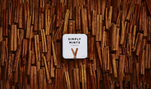A metal tin labeled "Simply Gum - Cinnamon Mints" by Simply Gum features two cinnamon sticks illustrated below the text, hinting at a delightful fall flavor. These cinnamon mints have a net weight of 1.1 oz (30 g).