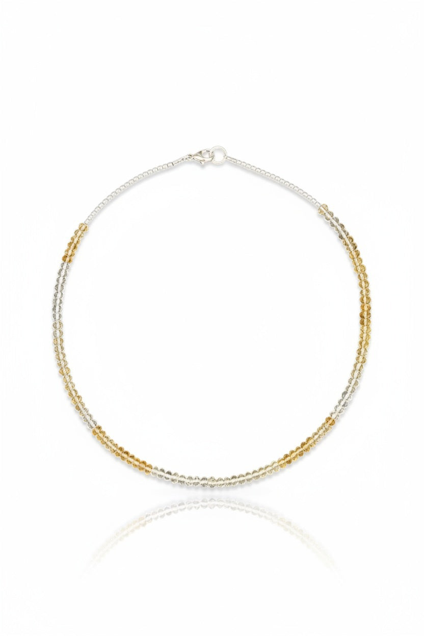 The ANN LIGHTFOOT - FACETED CITRINE RAS DU COU NECKLACE features faceted citrine stones with alternating silver and gold beads in a symmetrical design, secured by a sterling silver clasp, shown on a plain white background.