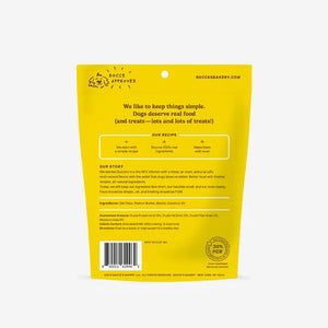A yellow and cream BOCCE'S BAKERY BAC N NUTTY BISCUITS bag features wheat-free, bone-shaped dog treats made with peanut butter and bacon.