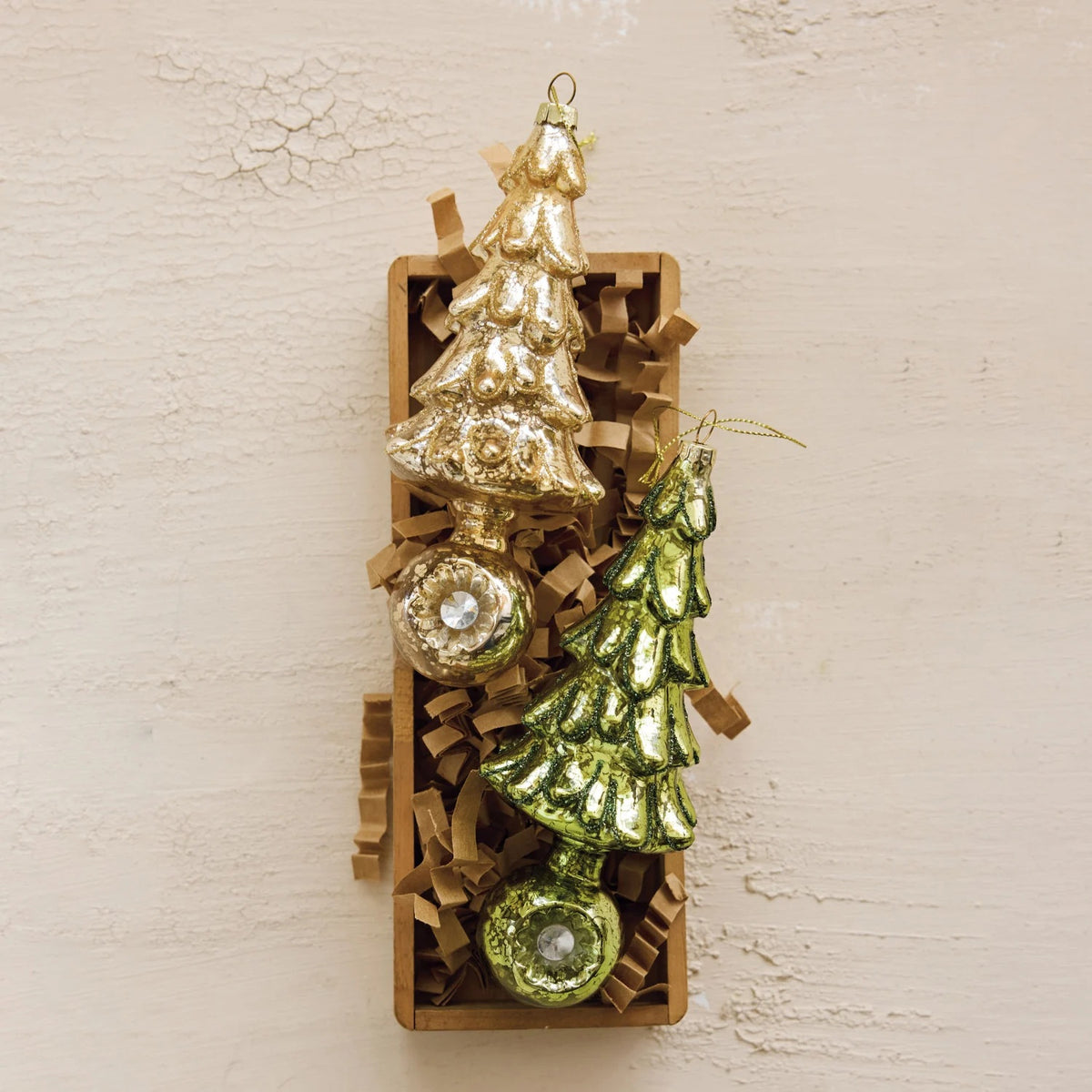 Two MERCURY GLASS TREE ORNAMENT WITH WITCH’S EYE BASE ornaments, one green and one gold, each featuring a sphere base with a reflective center element.