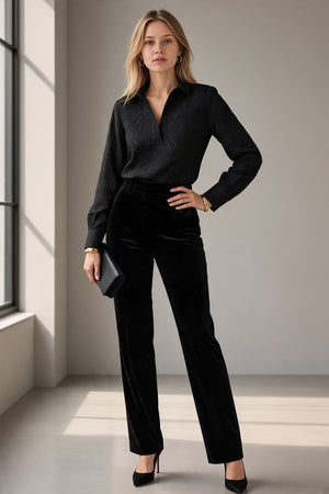 A woman wearing a HINSON WU - MONA LONG SLEEVE BONDED LACE SHIRT in black, paired with black trousers, black heels, and a black clutch.
