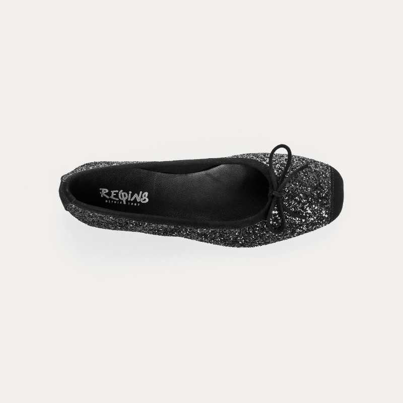 The REQINS Harmony Sequin Ballerina Flats in Noir feature black sequins, black toe caps, and small bows—bringing a touch of everyday luxury against a plain light background.