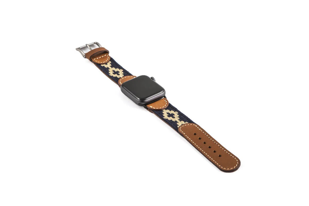 The LA MATERA CORBINA Apple Watch Band in Space Black features a rectangular screen and artisan-crafted brown leather strap with a black woven band adorned with tan diamond patterns, showcasing elegance on a crisp white background.