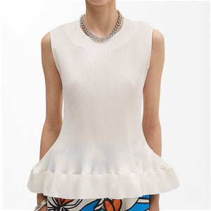 A person wearing the MEIMEIJ Pleated Sleeveless Top with a flared hem and a silver chain necklace. The lower part of printed summer trousers with a floral or abstract design is visible against the plain white background.