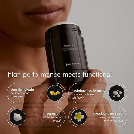 A person holds a black stick of JACK HENRY - DEODORANT HINOKI CYPRESS near their lips. Text highlights zinc ricinoleate, lactobacillus ferment, magnesium, and meadowfoam seed in this natural, aluminum-free JACK HENRY formula.