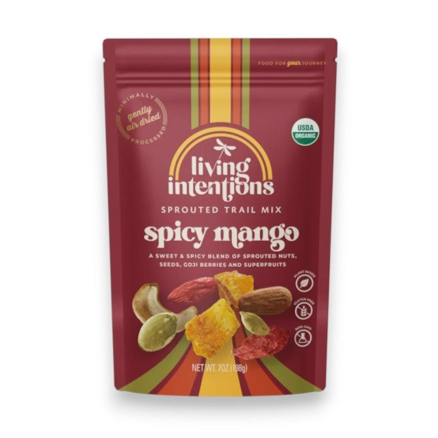 A vibrant red pouch of LIVING INTENTIONS SPROUTED TRAIL MIX SPICY MANGO displays images of dried mango, seeds, and nuts. The packaging from LIVING INTENTIONS highlights USDA Organic certification and “gently air-dried” labeling, making this organic trail mix a wholesome and flavorful snack choice.