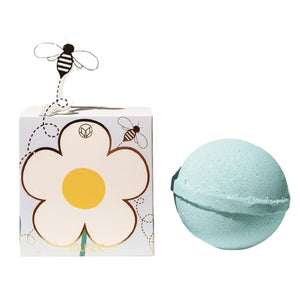 A light blue MUSEE - DAISY BATH BALM by MUSEE rests beside a beautifully decorated box featuring a white daisy with a yellow center and playful cartoon bees, including one bee attached on a wire. This delightful set is perfect for anyone who loves natural bath products and enjoys indulging in soothing bath balms.