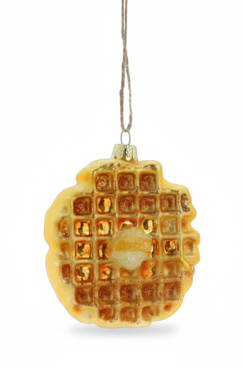 A 3.25-inch EGGO WAFFLE ORNAMENT by Cody Foster, shaped like a waffle with a dollop of butter on top and hanging from a twine loop.