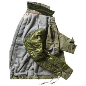 The RELWEN Pile-Lined Chore Coat in Palm Green is a stylish workwear jacket with a green quilted sleeve, olive-green collar and cuffs, and a soft gray fleece body with rugged lining, shown lying open on a white background.