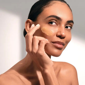 A tube of ELEMIS - PRO-COLLAGEN GLOW BOOST EXFOLIATOR by ELEMIS - STEINER lies next to a dollop of its contents on a light surface. Text explains the key ingredients: starflower oil, rose & mimosa waxes, padina pavonica, and cellulose exfoliating beads, highlighting their benefits.