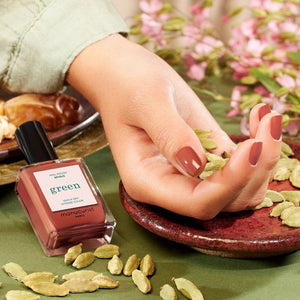 A chart displaying twelve lipstick shades—each swatched alongside its name and color description—features a range of reds and oranges, from coral and cherry to terracotta, pomegranate, and deep berry tones. These hues are designed to perfectly complement your favorite vegan nail polish or pair flawlessly with MANUCURIST - GREEN™ NAIL POLISH IN BRICK by MANUCURIST INC for a coordinated, striking look.