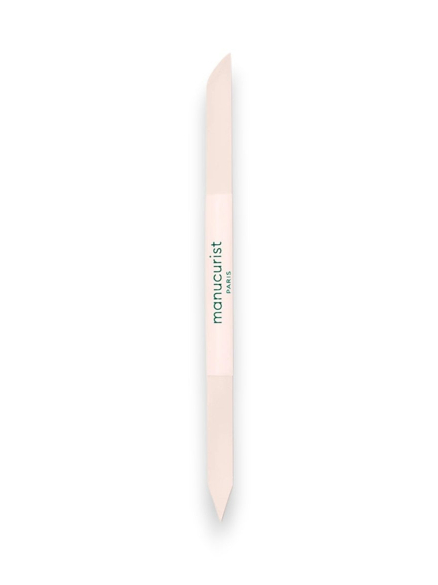 The MANUCURIST - GLASS CUTICLE PUSHER by MANUCURIST INC is a reusable, double-ended white glass cuticle tool with pointed tips and "manucurist PARIS" printed in green at the center, shown on a plain white background.