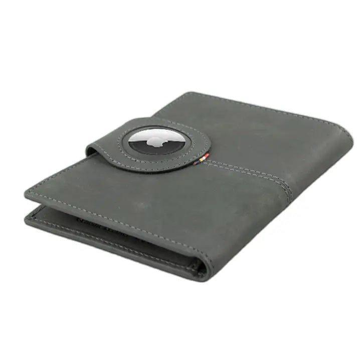 The GARZINI RFID-blocking leather passport holder in Carbon Black features multiple card slots, a pen holder, angled pockets, a transparent ID window, an Airtag compartment, and a snap-button closure flap.