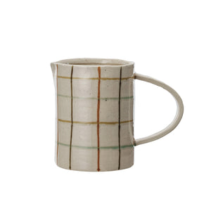 Close-up of the HAND-PAINTED STONEWARE PITCHER by CREATIVE COOP, showcasing an artisanal beige surface with a grid of brown, orange, and light green, plus small dark speckles for added charm.