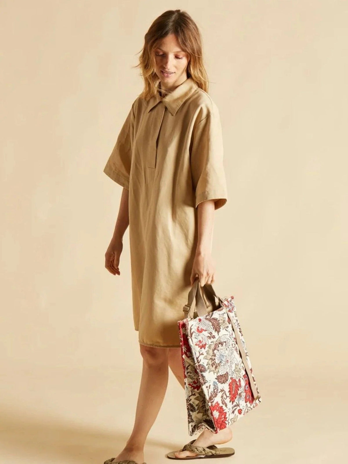 The INOUI EDITIONS - PIPPA STREET BAG by INOUI, a rectangular 100% cotton quilted crossbody tote with beige handles and a strap, is displayed against a plain background. The 40x34x12 cm bag showcases a colorful floral pattern featuring red, blue, and brown flowers on a light background.