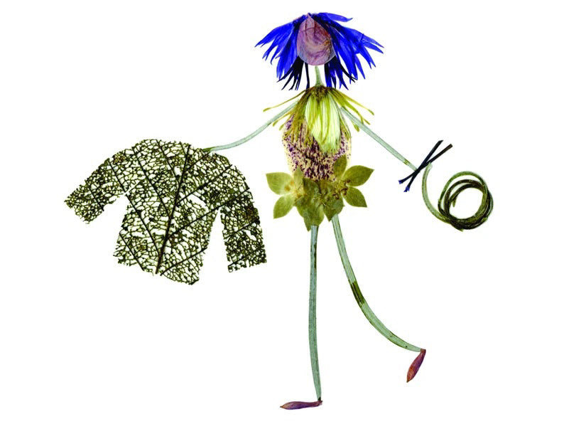 The PETAL PEOPLE PRESS - KNIT AND PURL GREETING CARD features a whimsical figure made from flower petals and leaves, with blue petal hair, a leafy jacket, and swirls of grass on a plain white background.
