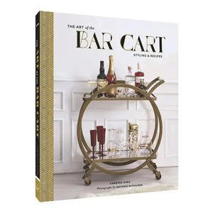 A close-up of THE ART OF THE BAR CART BY VANESSA DINA from CHRONICLE BOOKS, featuring a gold-patterned spine and an illustrated bar cart on the cover—ideal for drink ideas and elegant home bar decor.