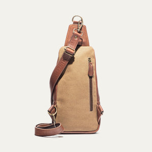 The WILL LEATHER GOODS - Zip Around Sling Bag in Cognac, featuring full-grain leather, a front zipper pocket, adjustable strap, and top handle, is shown upright against a plain light background.
