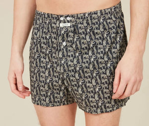A person stands against a plain background, wearing HARTFORD – COTTON BOXER SHORTS, PATTERN by HARTFORD, featuring a light-colored animal print and crafted from upcycled cotton boxer briefs. Only the lower torso and upper legs are visible.