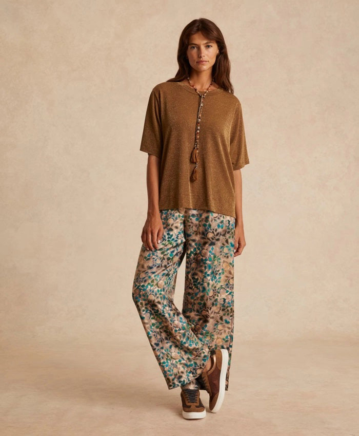 The MOMONI - IORA LUREX JERSEY T SHIRT by MOMONI is a red, short-sleeve, loose-fitting T-shirt with a subtle shimmer. Crafted from soft lurex jersey, this shirt features a round neckline and is made of a soft, lightweight material. Made in Italy. The background is plain white.