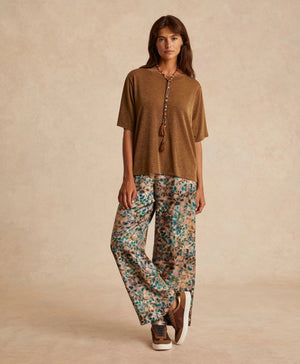 The MOMONI - IORA LUREX JERSEY T SHIRT by MOMONI is a red, short-sleeve, loose-fitting T-shirt with a subtle shimmer. Crafted from soft lurex jersey, this shirt features a round neckline and is made of a soft, lightweight material. Made in Italy. The background is plain white.