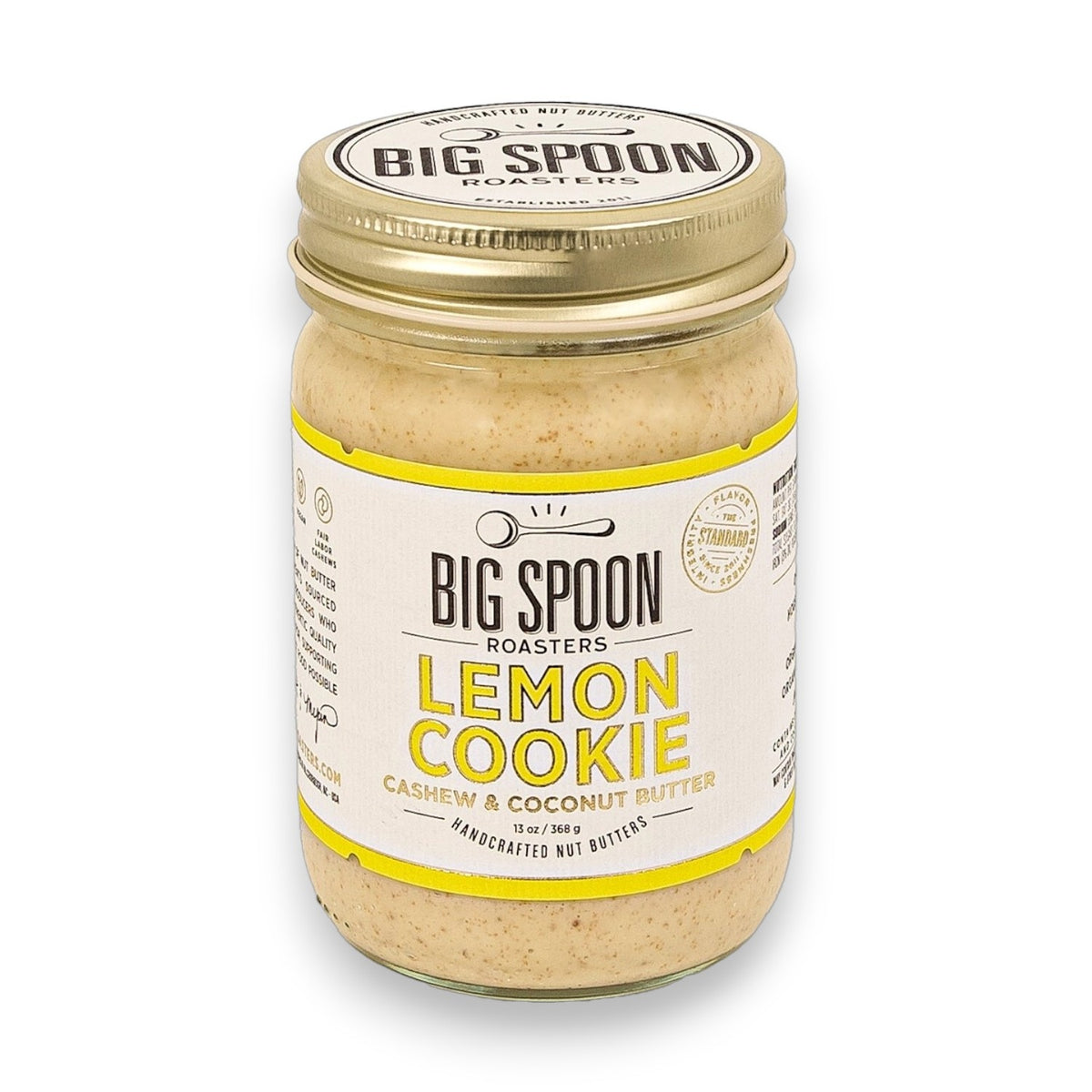 A jar of BIG SPOON ROASTERS Cashew Lemon Coconut Nut Butter with a metal lid features a white and yellow label with black text. This handcrafted nut butter by BIG SPOON ROASTERS is ideal for sweet, zesty snacking.
