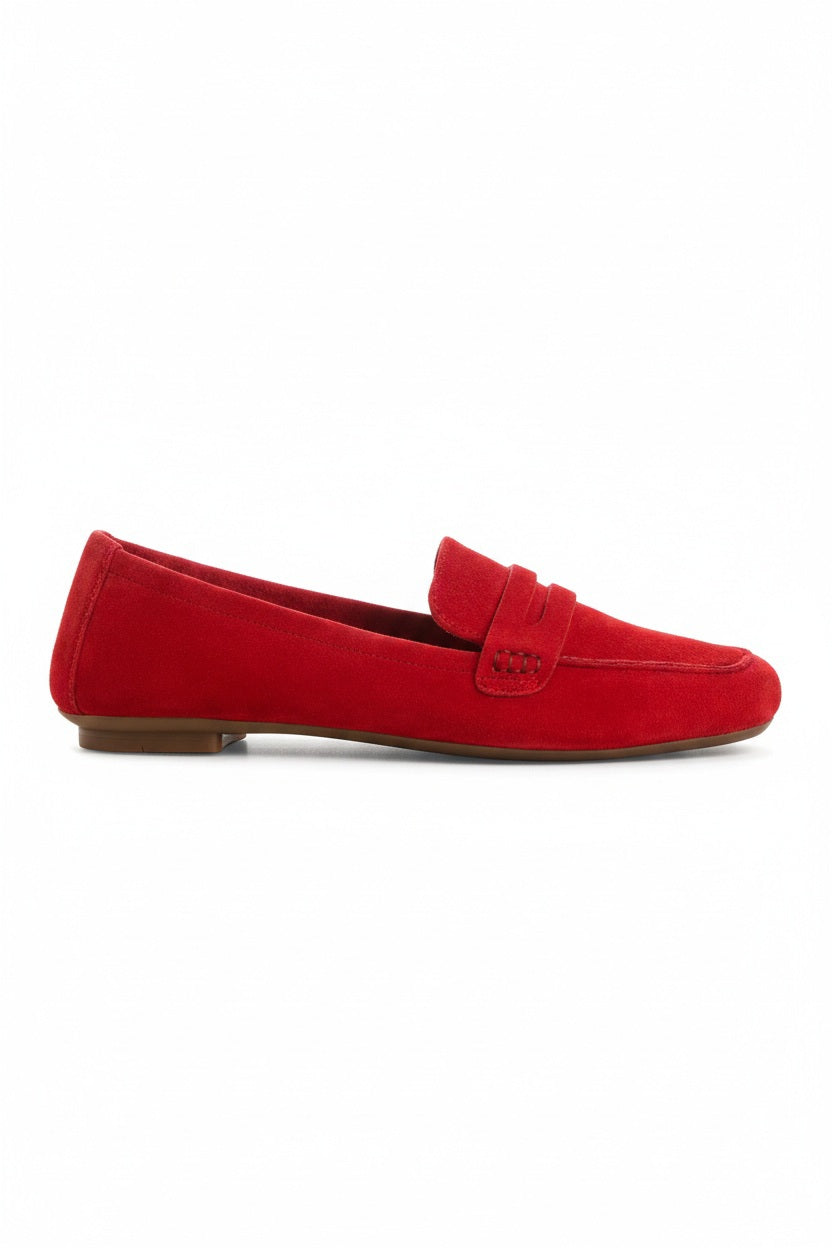 The REQINS HEMA Suede Loafer in Rouge features bright red suede, low heels, a classic penny loafer design, and a supple leather insole—all crafted with artisanal expertise and shown on a plain light background.