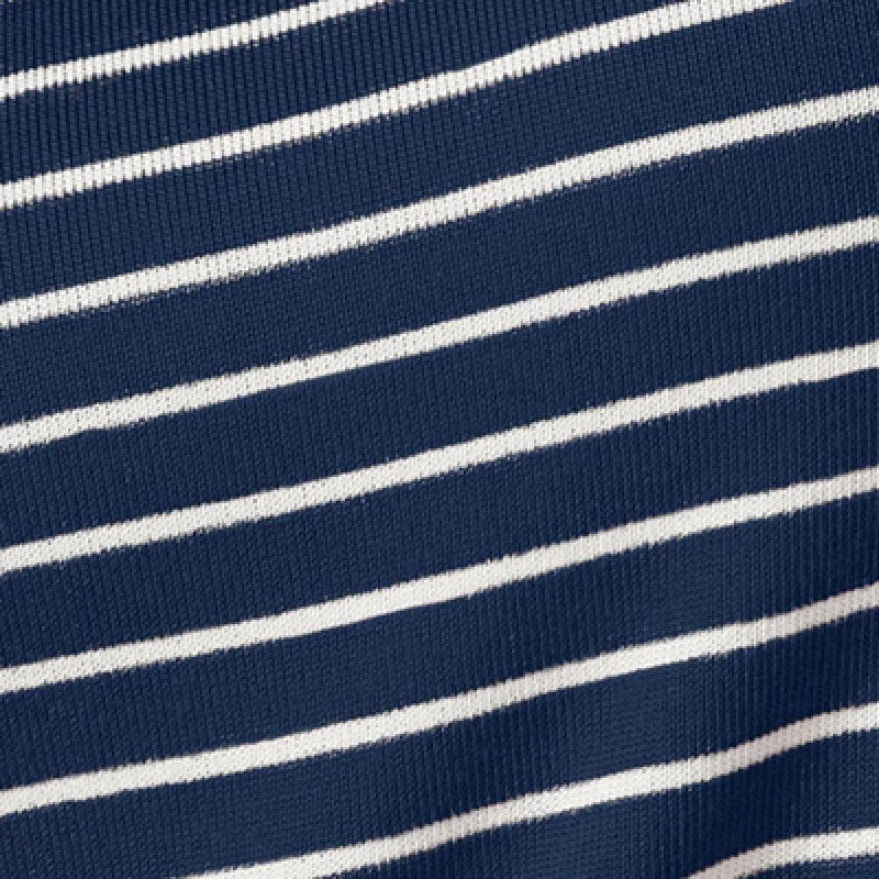 A woman wears a navy blue SOFTIES - DREAM JERSEY COWL NECK LOUNGE SET consisting of a long-sleeved top and wide-leg trousers.