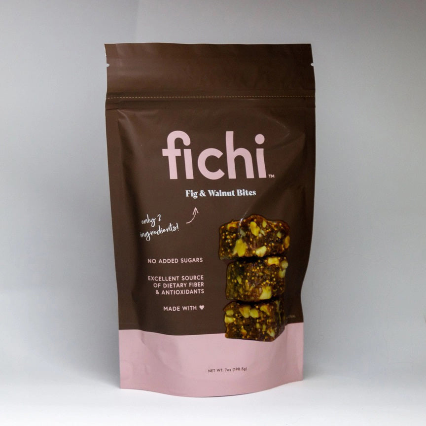 A brown and pink resealable bag labeled FICHI FIG AND WALNUT BITES from FICHI shows snack bites. This vegan, gluten-free snack features no added sugars, dietary fiber, antioxidants, and simple ingredients.