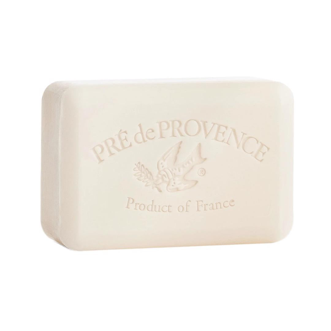 A white rectangular bar of French soap branded by European Soaps, LLC, with "Pré de Provence" etched on the top alongside an image of a bird carrying a branch. The words "Product of France" are engraved beneath, highlighting its quad-milled craftsmanship and enriched shea butter formula. This is the MILK BAR SOAP 150G variety.