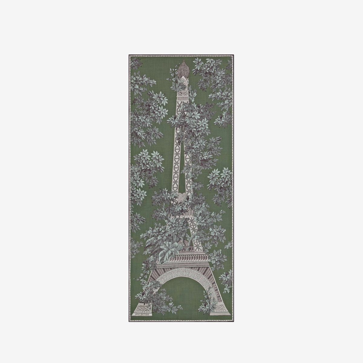 A person with short hair wears a long black dress and the INOUI EDITIONS 1889 WOOL SCAR FIN KHAKI scarf by INOUI—a green patterned accessory featuring intricate floral and geometric designs, crafted from 100% wool in India—while standing against a plain white background.