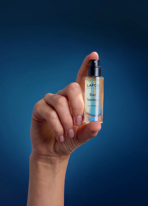 A clear glass perfume bottle labeled “LAFCO - FINE FRAGRANCE, BARE SUMMER 10ML” from LAFCO, topped with a turquoise marbled cap, this essential oil fragrance features an elegant blend that’s both refreshing and modern.